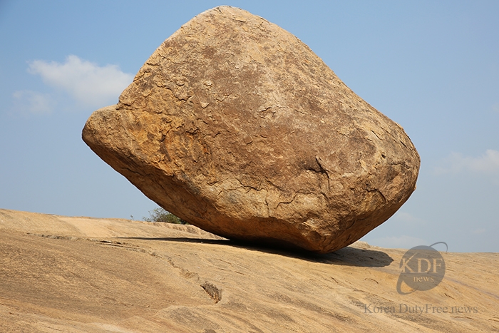 바위 절벽 위에 올려져 있는 둥그런 바위 크리쉬나버터볼의 모습 