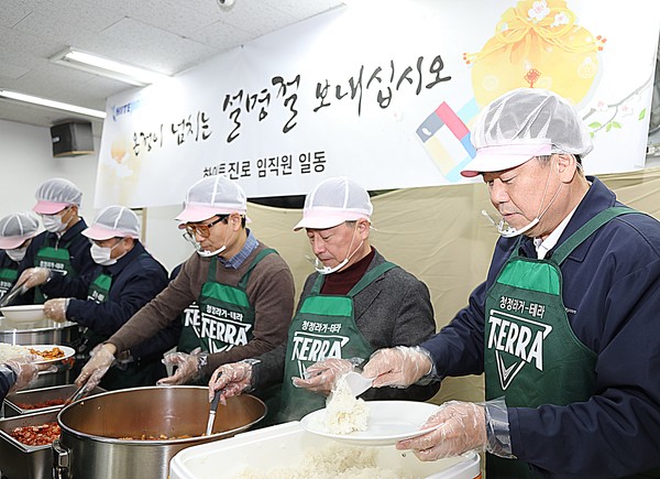 김인규 하이트진로 사장(오른쪽에서 첫번째)과 임직원들이 23일 서울역 인근 무료급식소 '따스한 채움터'에서 노숙인들에게 배식 나눔봉사 활동을 하고 있다.