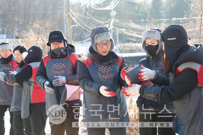 롯데건설 박현철 부회장(오른쪽 세번째)과 배우 정애리(오른쪽 두번째)가 임직원들과 함께 연탄을 나르고 있다.
