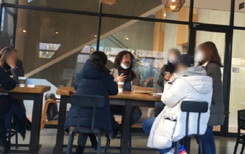 방송인 김어준이 서울 마포구 상암동의 한 커피전문점에서 마스크를 턱에 걸친 채 일행과 대화를 나누고 있다. 사진=온라인 커뮤니티 캡처