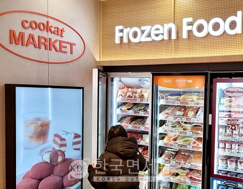 GS25 합정프리미엄점에 시범 도입된 쿠캣 냉동매대에서 한 고객이 상품을 고르고 있다.