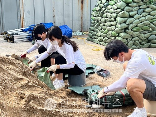BBQ 대학생 봉사단 올리버스 단원들이 반포 종합운동장에서 물막이용 모래주머니를 제작하고 있다.