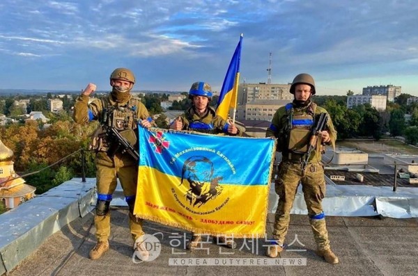 하르키우 쿠피안스크 시립 건물에 우크라이나 국기를 게양하는 군인