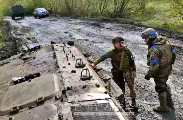 우크라이나 병사가 '리만'이라고 적힌 장갑차를 쳐다보고 있다.