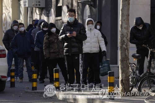 13일 중국 베이징 시민들이 추운 날씨 속에서 약국 앞에 길게 줄을 선 모습. AP 연합뉴스