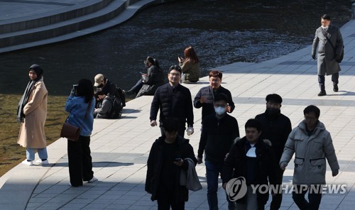 서울 오후 기온이 10도 안팎까지 오르는 등 따뜻한 날씨를 보인 지난 27일 서울 청계천에서 시민들이 물가에 앉아 시간을 보내고 있다. 연합뉴스