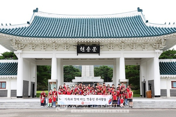 롯데건설 임직원과 가족들이 현충문 앞에서 봉사활동 후 기념 촬영을 하고 있다.
